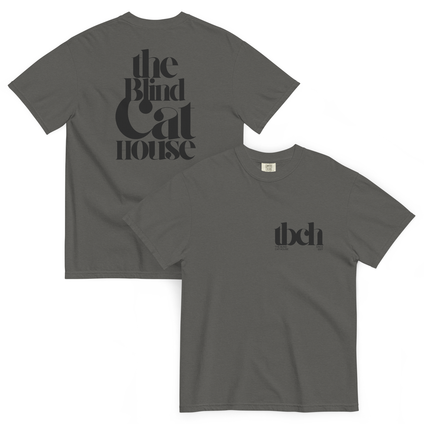 Pepper colored short sleeve t-shirt shown front and back on a white background. The back features large black typography reading "The Blind Cat House" in a bold, vintage-style font The front has a small black chest logo reading "tbch" with the blind cay house" and "since 2021" beneath it