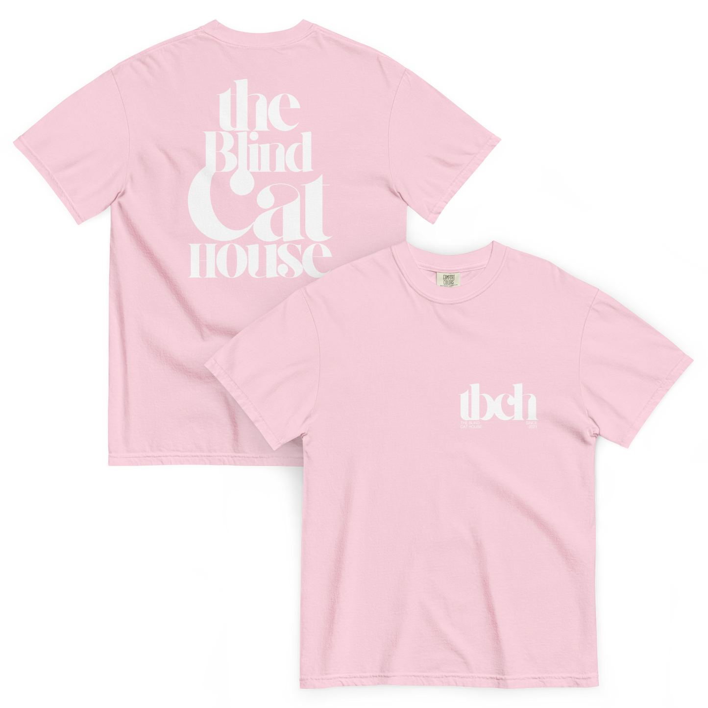 Light Pink colored short sleeve t-shirt shown front and back on a white background. The back features large white typography reading "The Blind Cat House" in a bold, vintage-style font The front has a small white chest logo reading "tbch" with the blind cay house" and "since 2021" beneath it